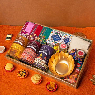 Assorted items including tea bags, a gold plate, and small containers on an orange surface.