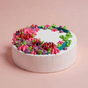Colorful flower-shaped cake on a pink background
