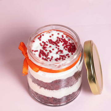 Layers of red velvet cake and cream cheese frosting in a dessert jar!