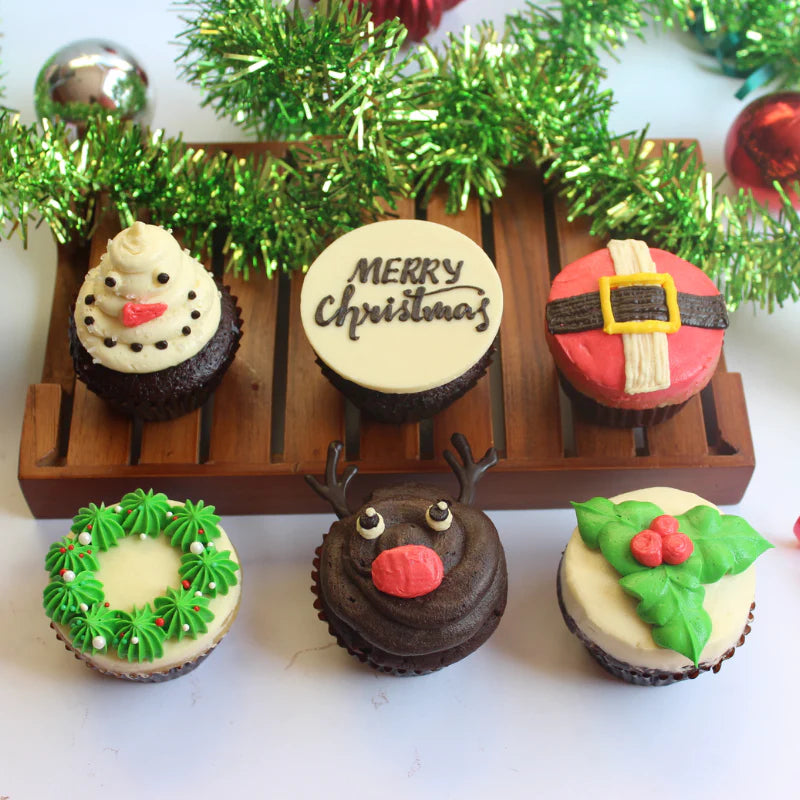 Christmas Themed Cupcakes with a snowman design, santa's suit, mistletoe, reindeer and other decorations you hang on the Christmas tree