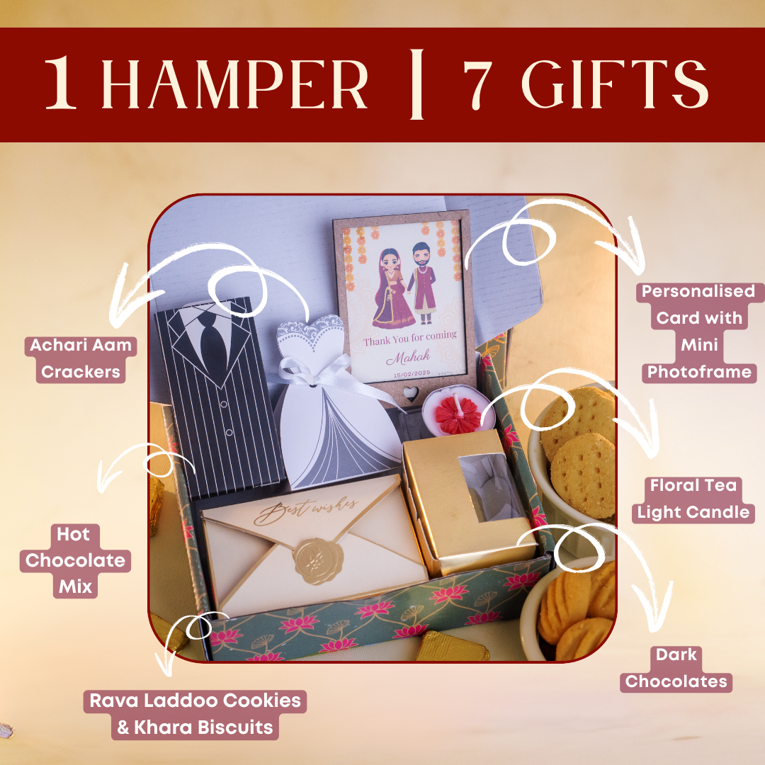 a close up shot of the open hamper filled with multiple items 
the items are a personalised card with mini photoframe, a floral tea light candle, a box of dark chocolates, a box of rava laddoo cookies and khara biscuits, a white bride dress box with achari aam crackers and a tuxedo groom box with hot chocolate mix 
it has a festive look perfect for a wedding gift hamper