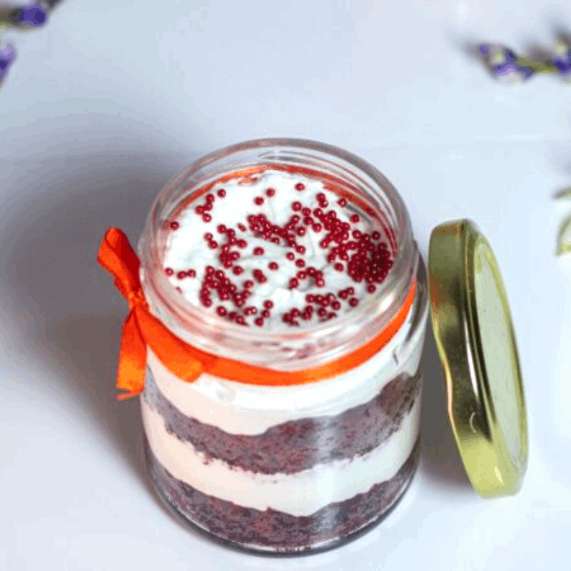 Layers of red velvet cake and cream cheese frosting in a dessert jar!