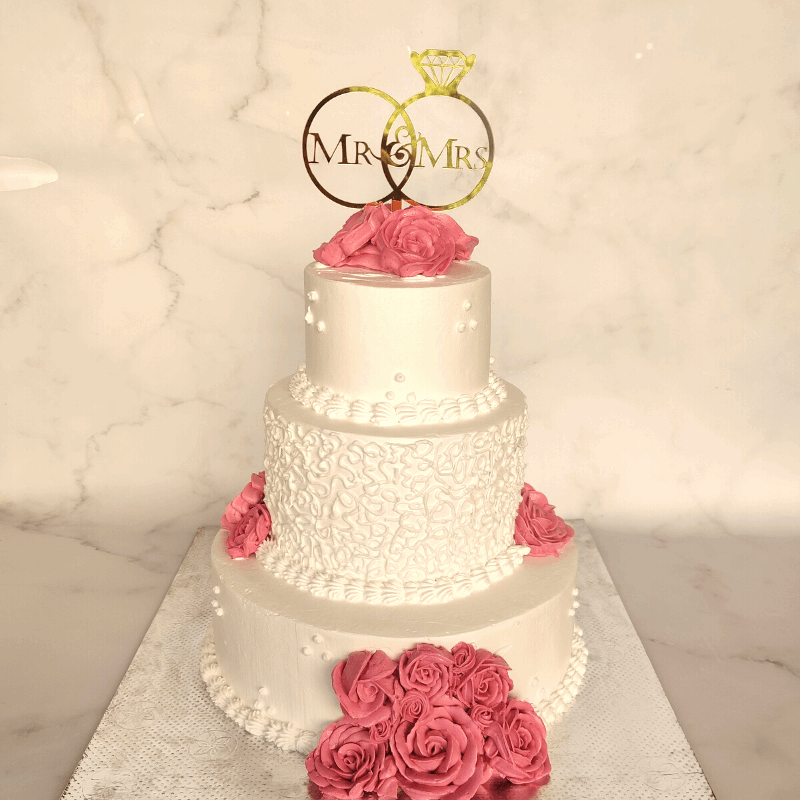 Common wedding cake topper decorated with pink cream roses as a three tier cake