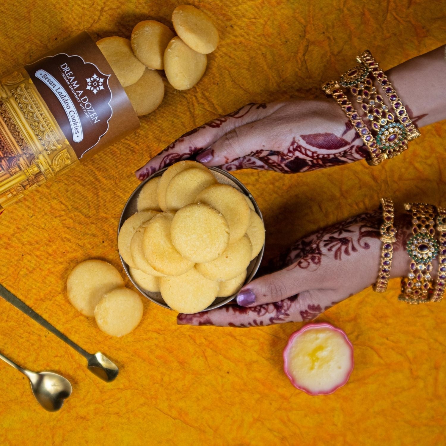 Hand holding a container of cookies with a decorative background
