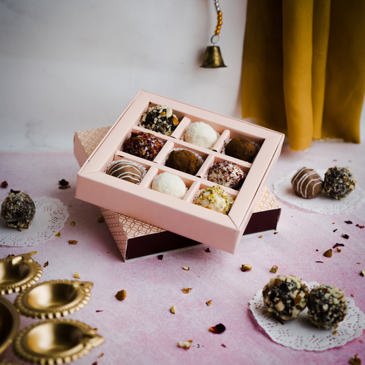 a straight shot of our wedding hamper gift - Box of Maharani truffles with coconut shavings in a pink cavity box costing just ₹360- royal, elegant and desi. personalised card and nine different flavoured delights. best wedding gift and return gift for weddings. personalised wedding gift