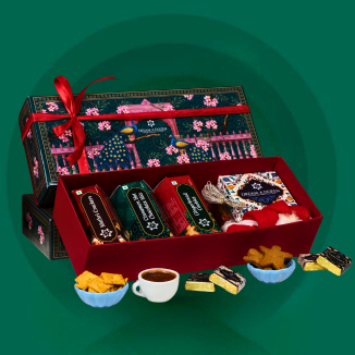 Gift set with tea and snacks on a green background