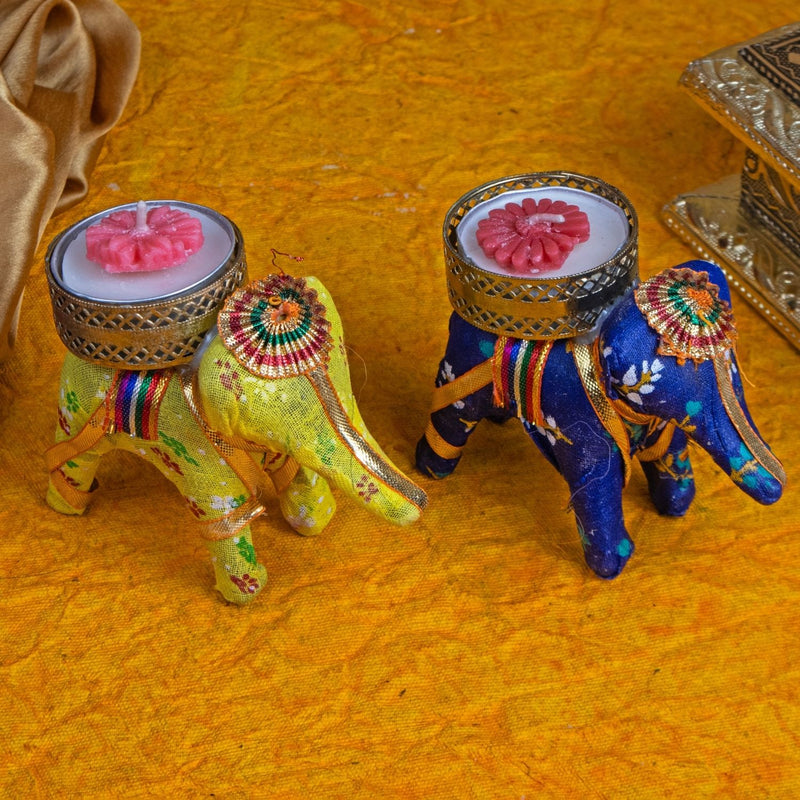 Decorative elephant figurines with candles on a textured surface