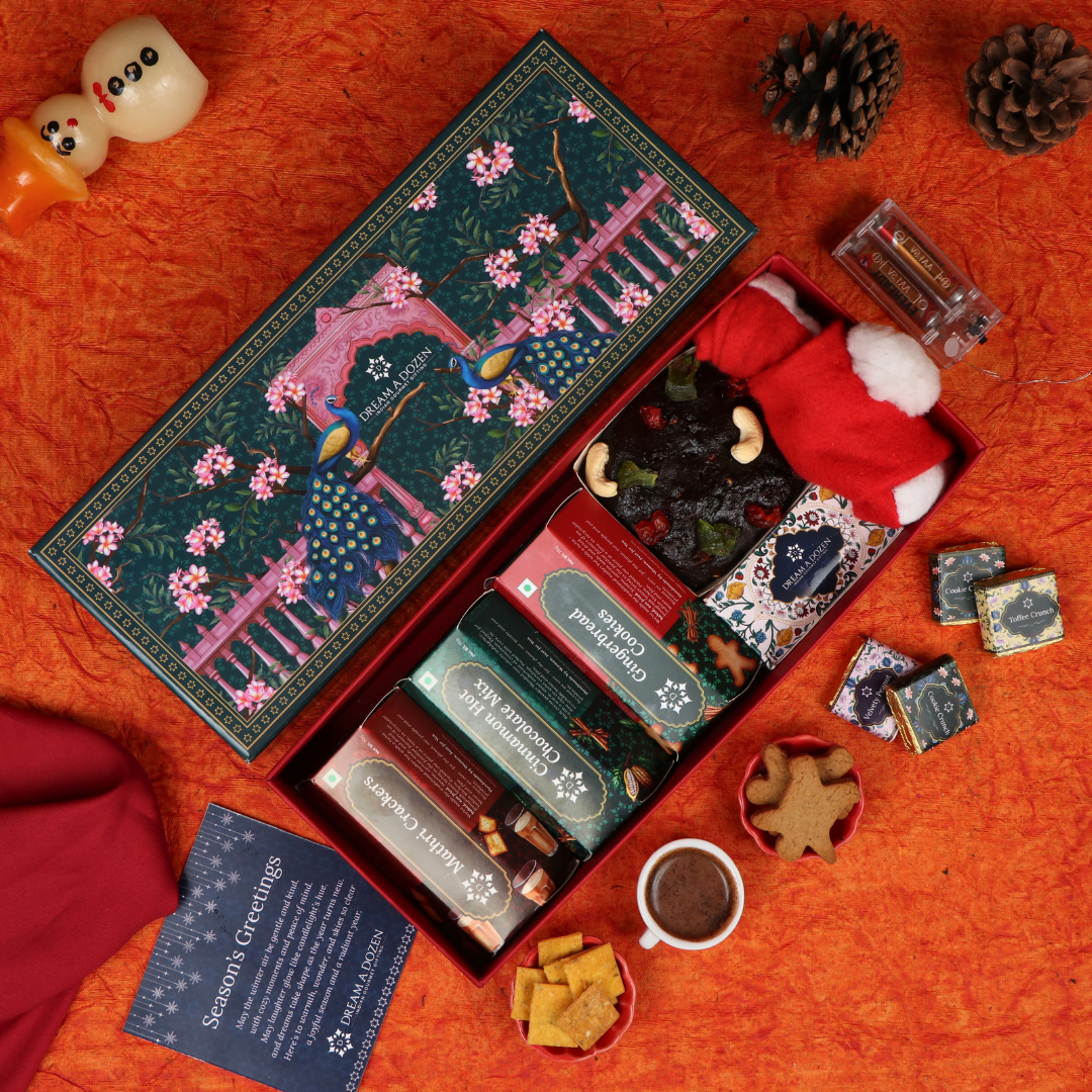 Decorative gift box with Christmas-themed items on an orange fabric background