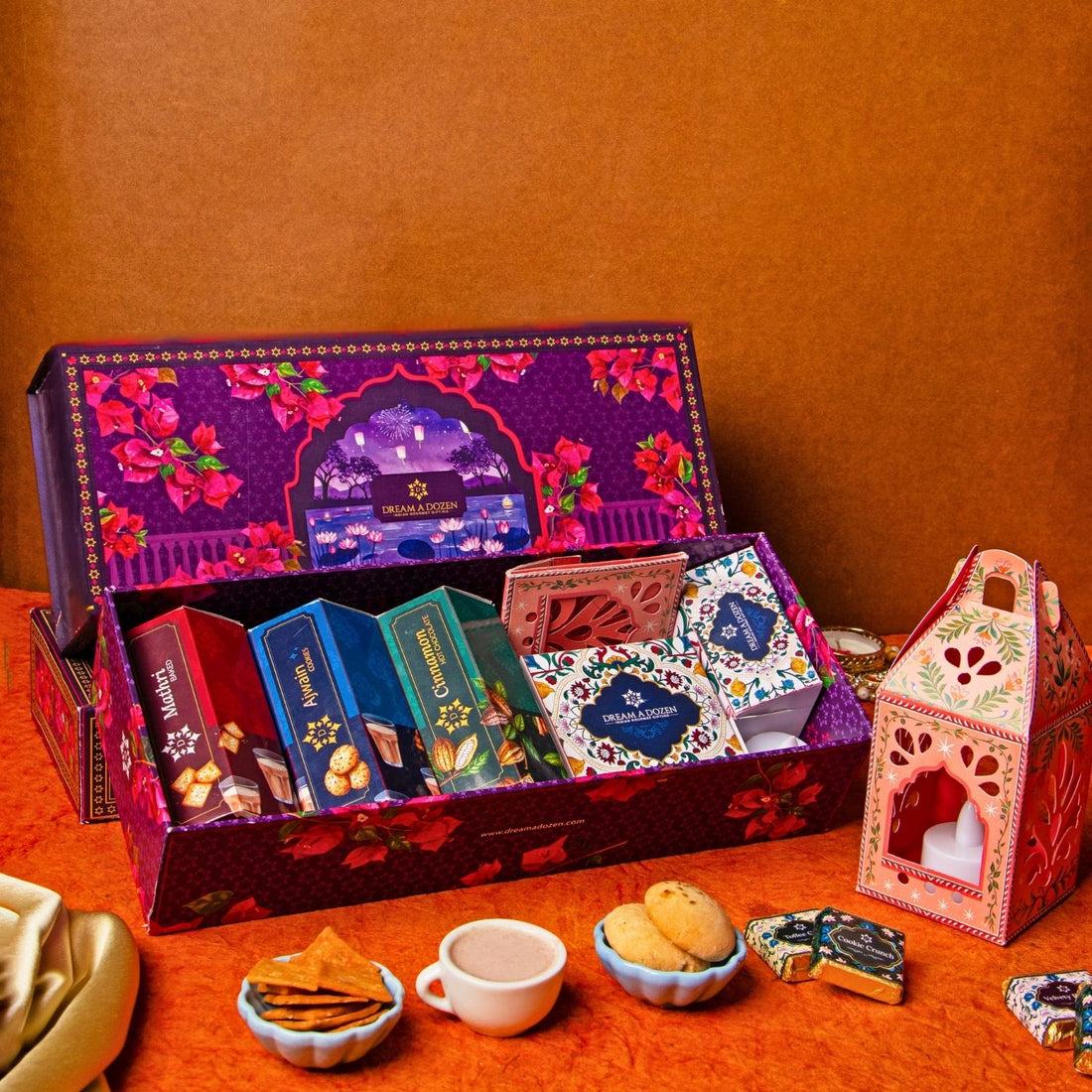 Decorative gift box with various items on a red surface