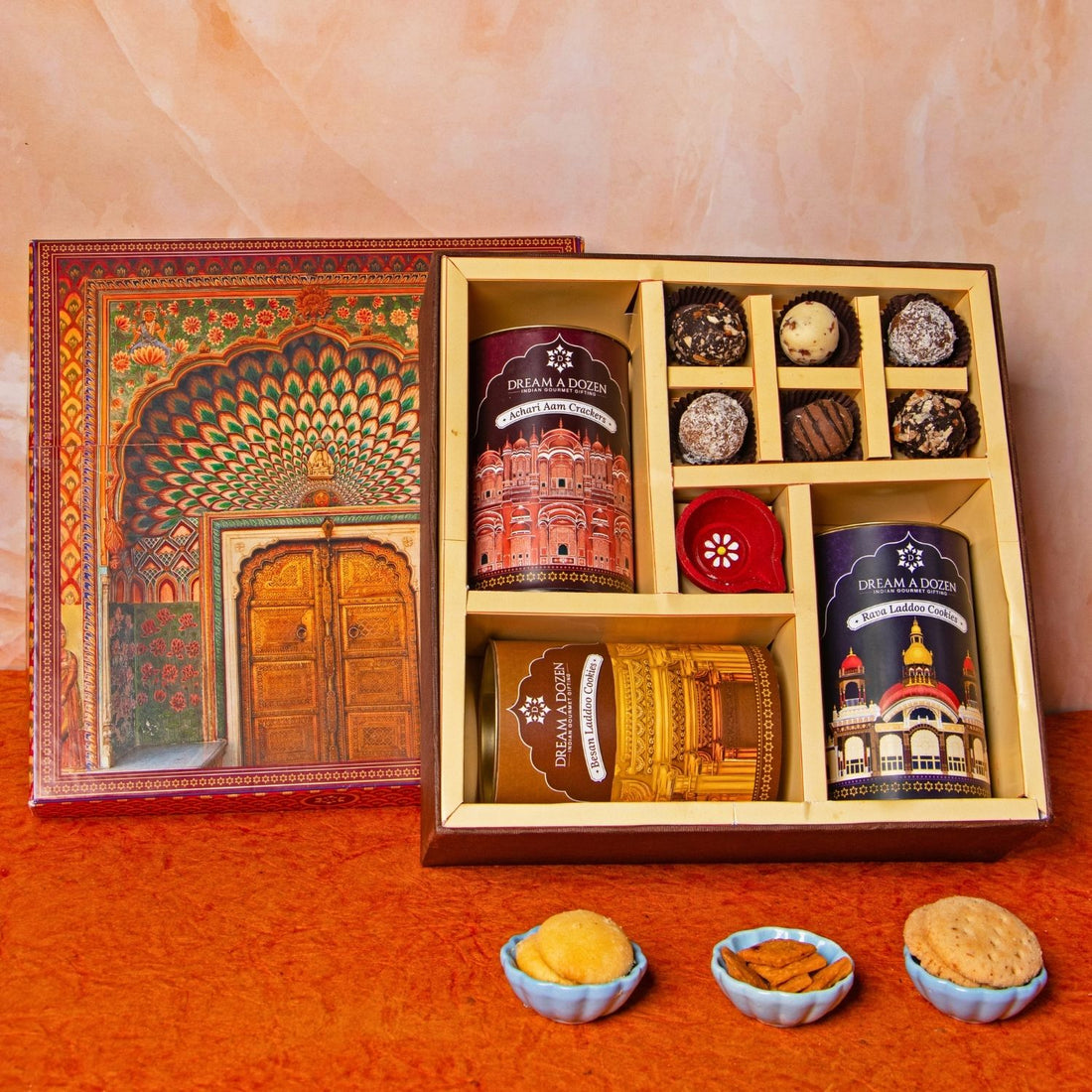 Gift set with tea and snacks in a decorative box on an orange surface