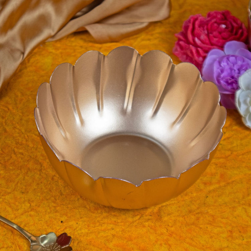Shell-shaped baking mold on a textured surface with flowers and a spoon in the background