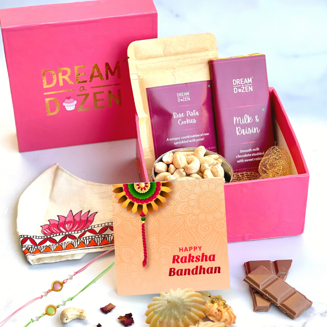 Hamper. Rakhi. Raksha Bandana. Gift Box. Rakhi Gift. Siblings. Gourmet. Rose pista cookies. Cashews milk chocolate. Madhubani face mask. Greeting card. Luxurious Hamper. Gifting.
