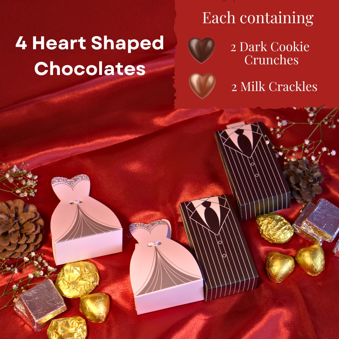 top side shot of Elegant bride and groom wedding favor boxes with 100% eggless heart-shaped chocolates – two dark cookie crunch and two milk crackles in each. Perfect budget-friendly marriage gift with PAN India shipping, set on a wooden table with fairy lights and golden floral decor.