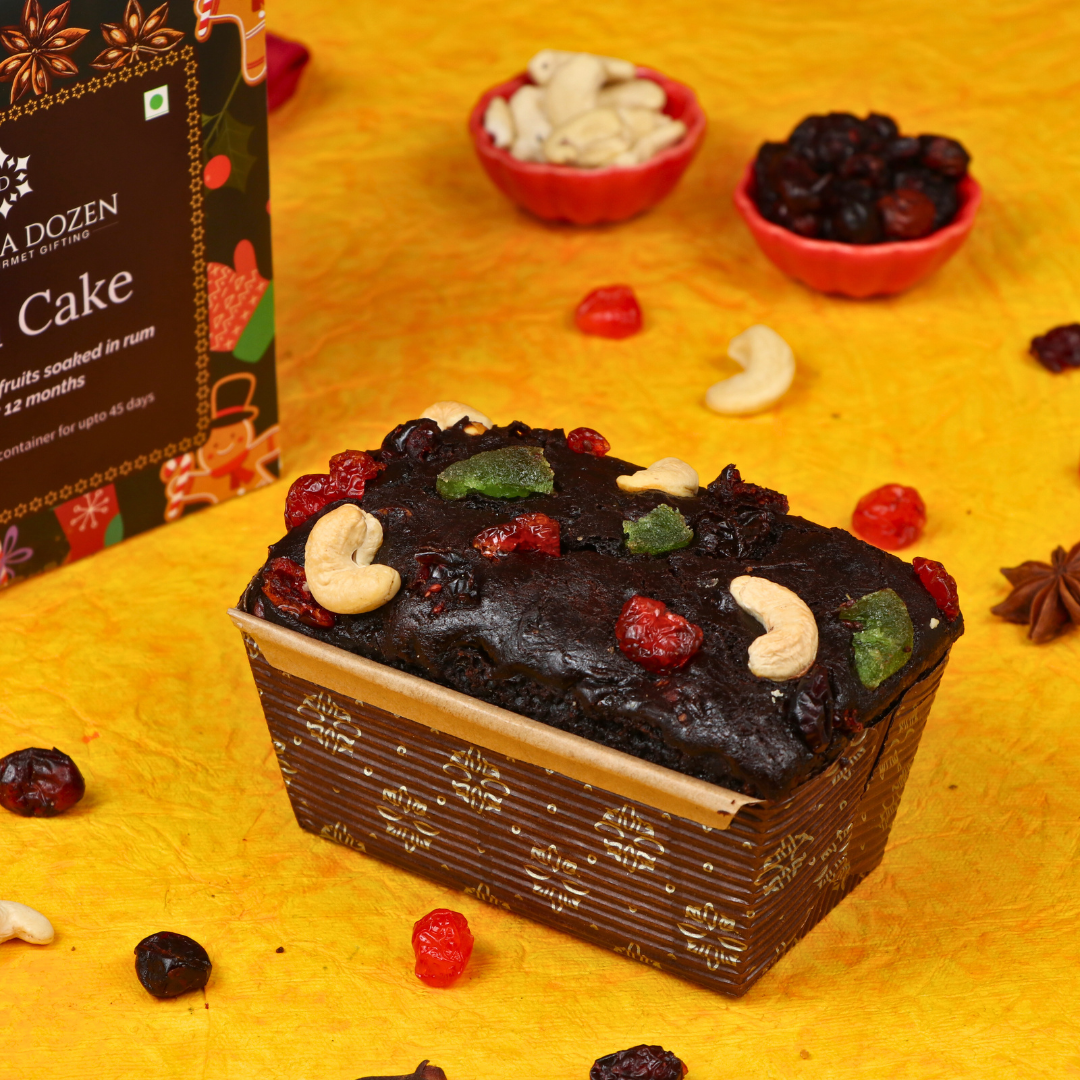 Plum cake with dried fruits on a yellow surface, with a box labeled 'Dream A Dozen' in the background.