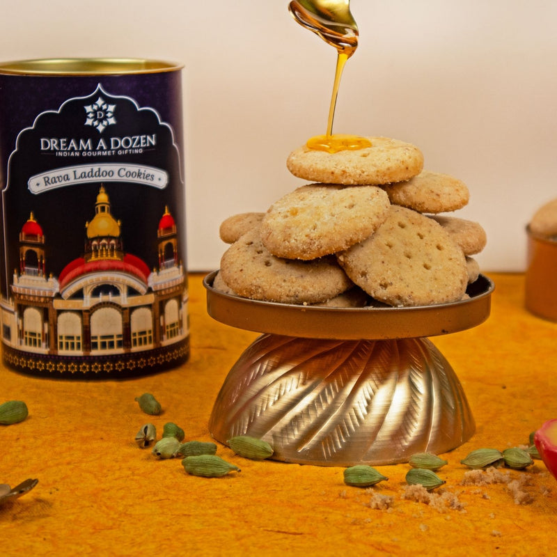 Cookies on a stand with honey being drizzled over them, next to a 'Dream A Dozen' cookie tin.