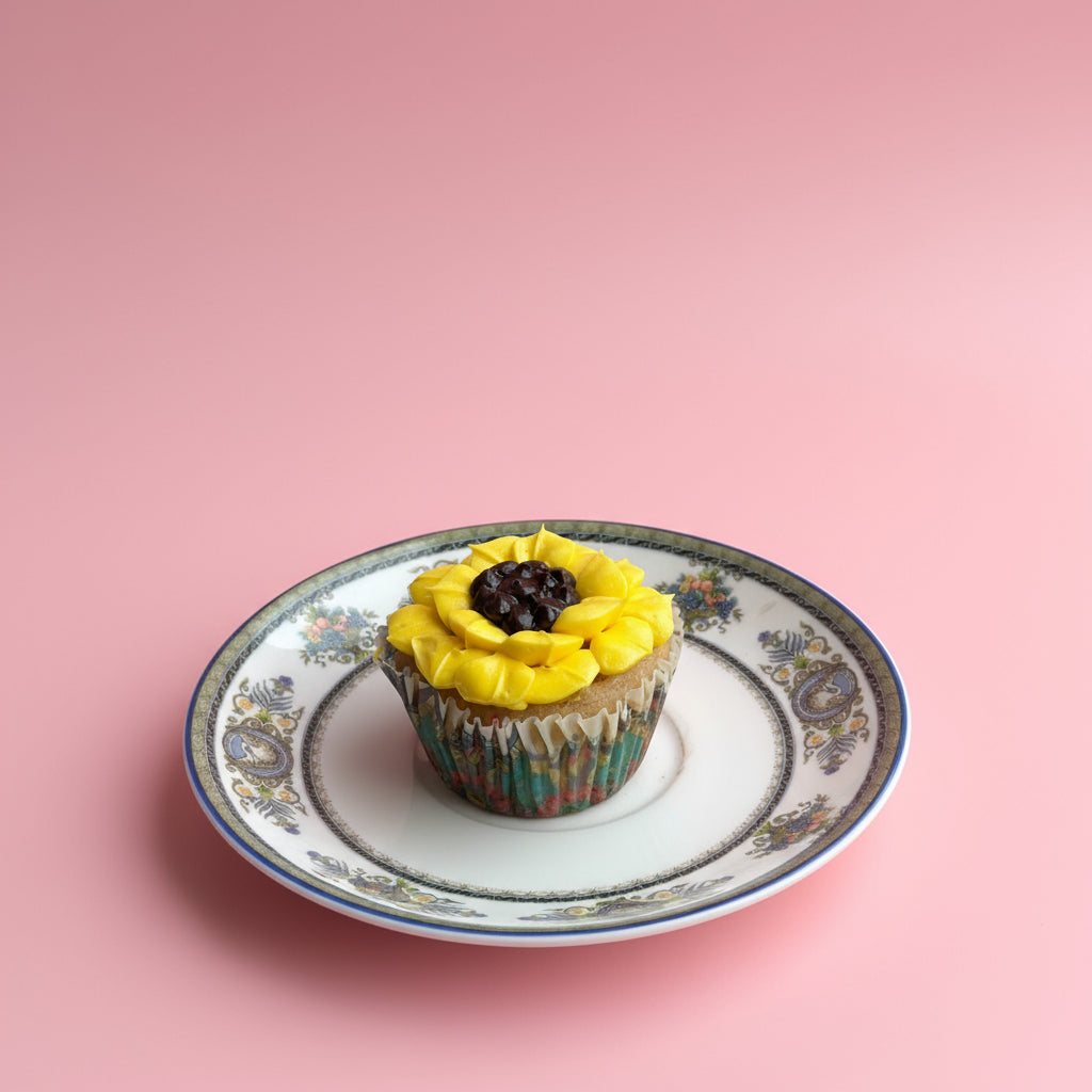 Colorful cupcakes with floral designs on a pink background