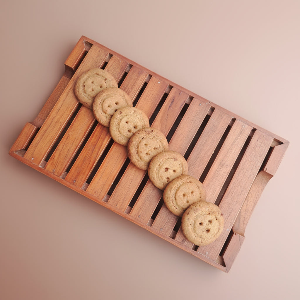 Cookies arranged on a wooden tray with a plain background