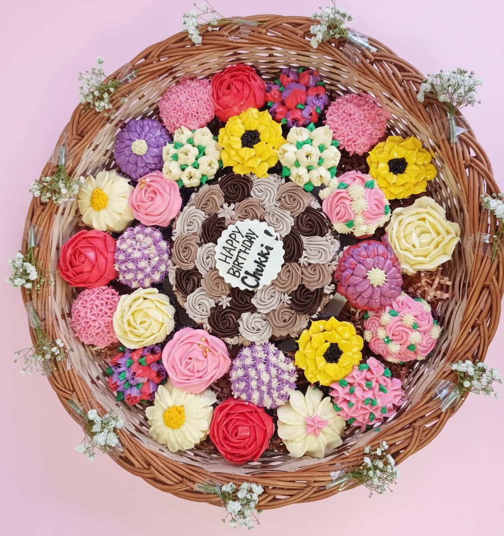 Decorative birthday cake with colorful flowers in a wicker basket on a pink background