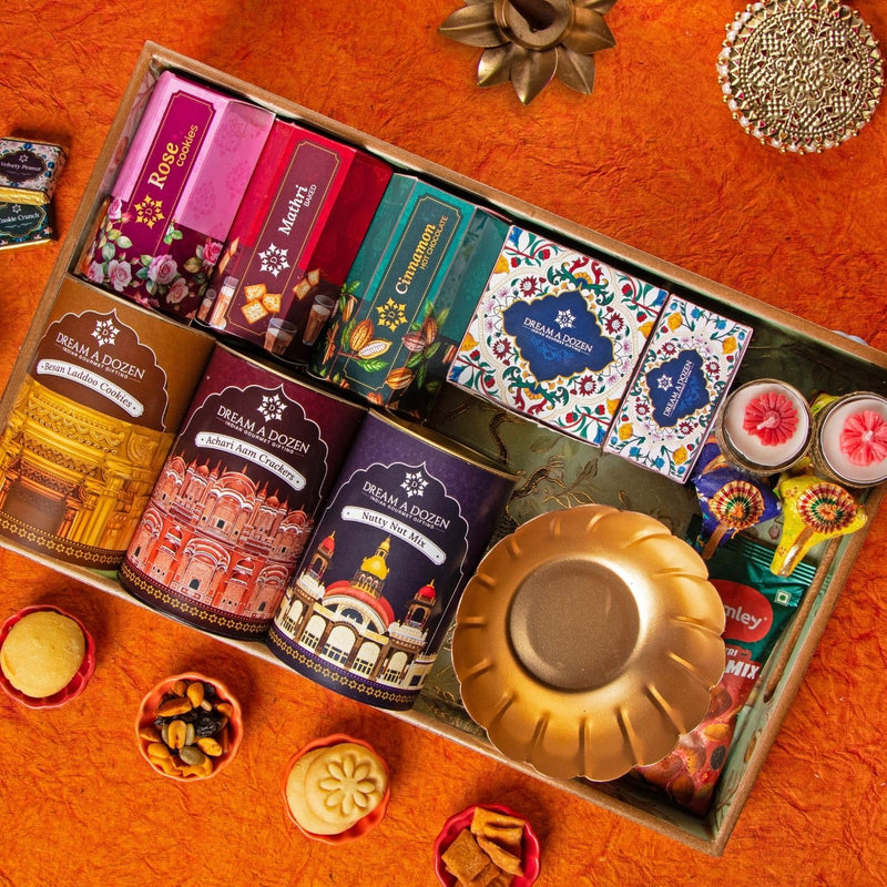 Assorted tea packages and decorative items in a box on an orange surface