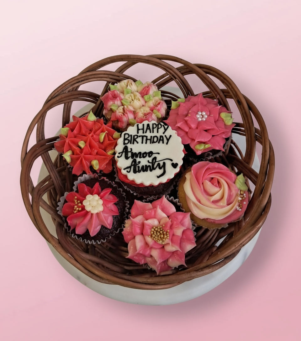 A floral cupcake basket with pink frosting and I love You message