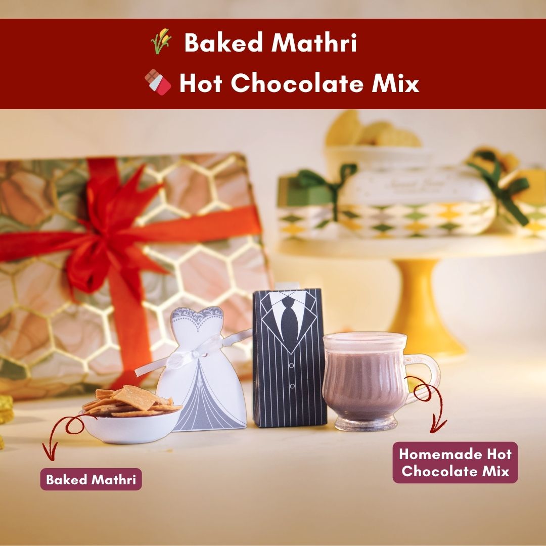 a close up front shot of a bride dress box with a bowl of tasty looking baked mathri beside it
on the other side of the bride dress is the groom tuxedo box with a cup of steaming homemade hot chocolate beside it
