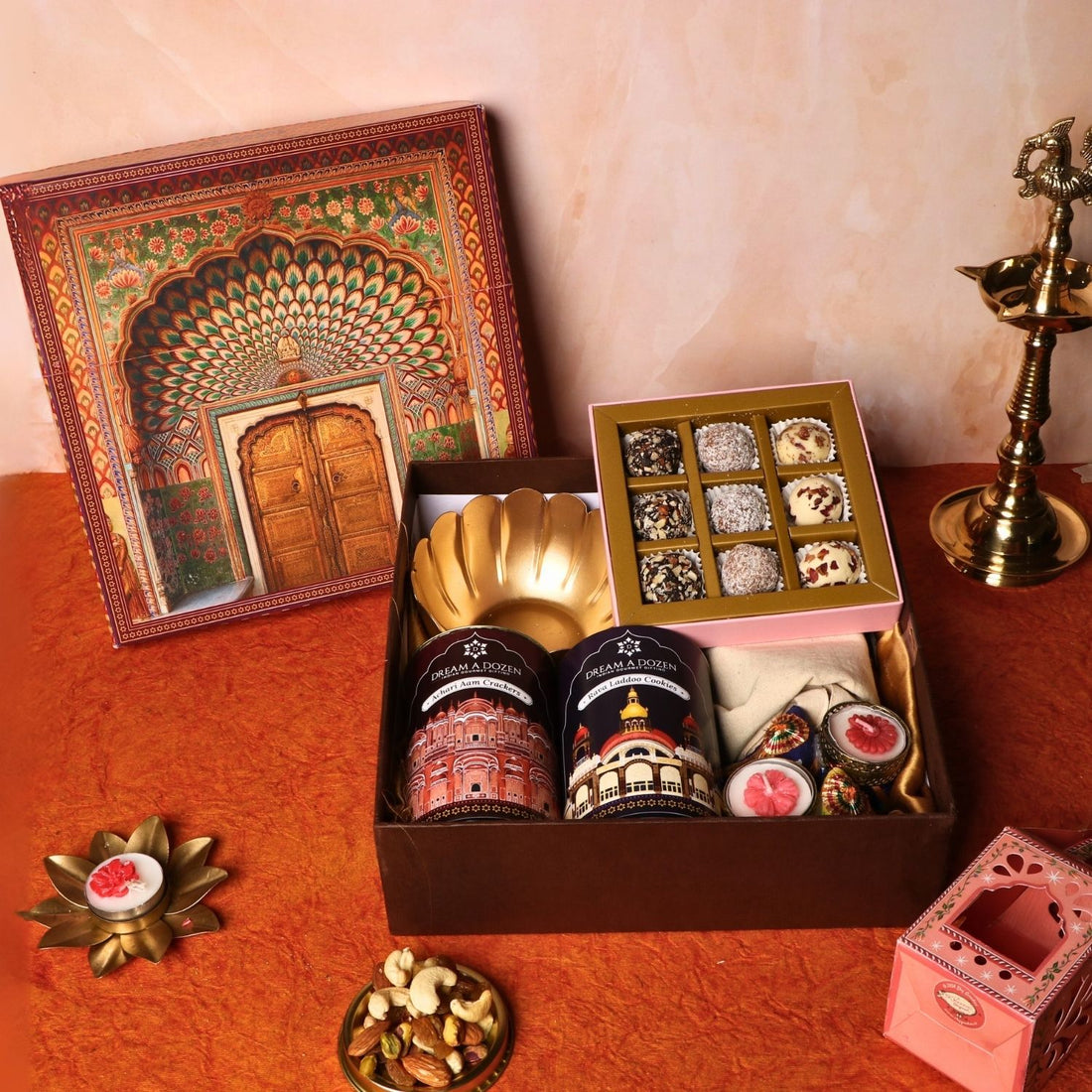 Gift box with traditional items including a gold plate, decorative boxes, and a small shrine on a red surface.