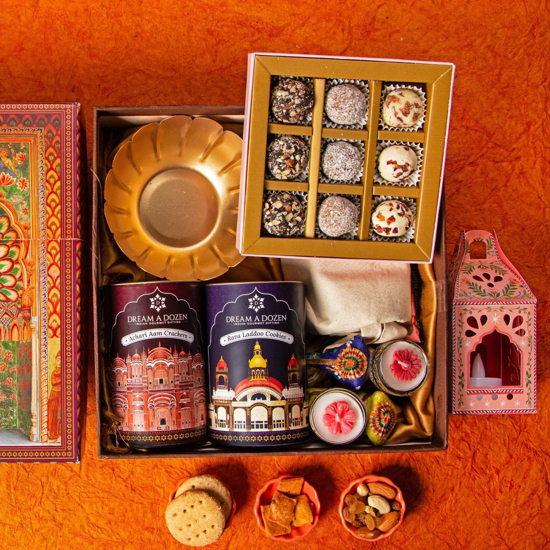 Gift box with traditional items including a gold plate, decorative boxes, and a small shrine on a red surface.