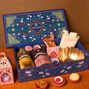 Decorative gift box with various items on a wooden surface