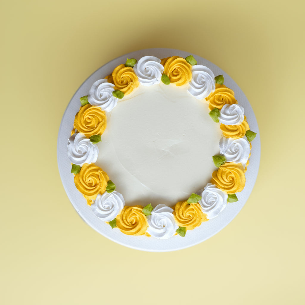 Decorative cake with yellow and white flowers on a yellow background