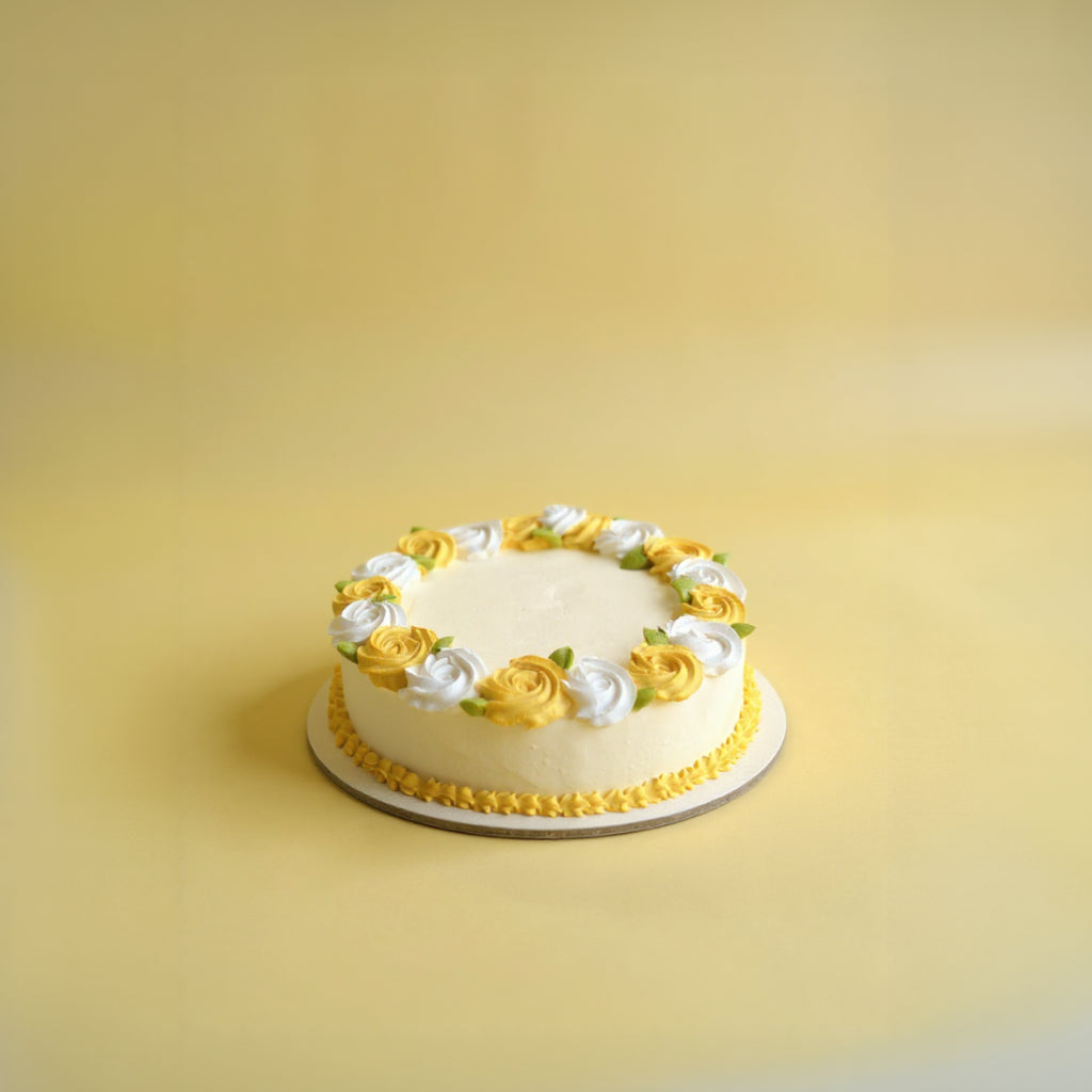 Decorative cake with yellow and white flowers on a yellow background