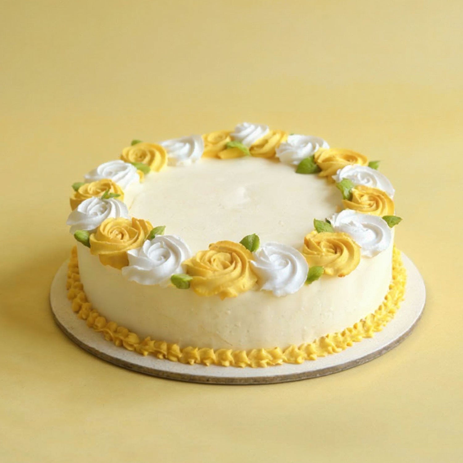 White cake with yellow and white floral decorations on a yellow background