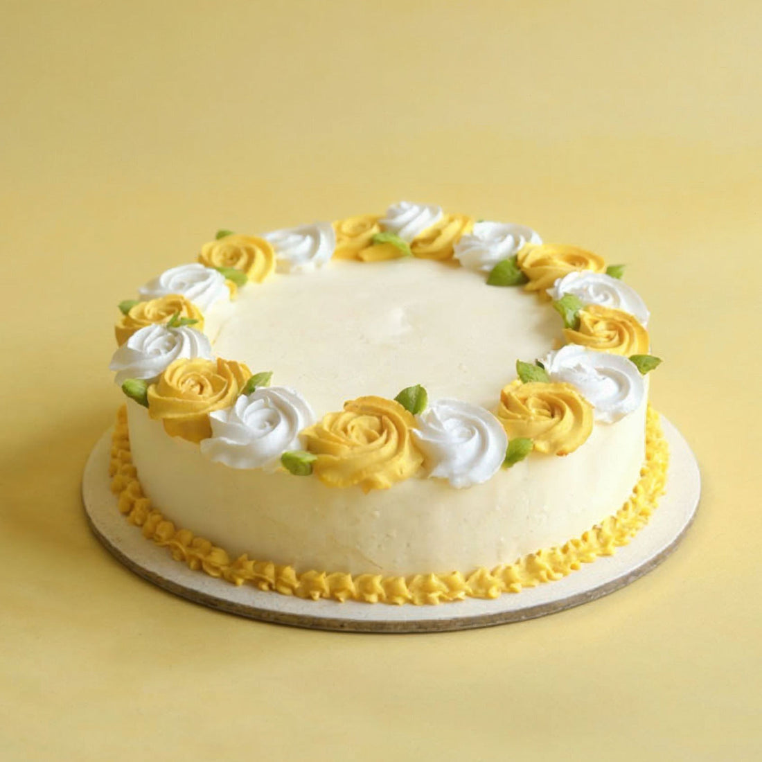 White cake with yellow and white floral decorations on a yellow background