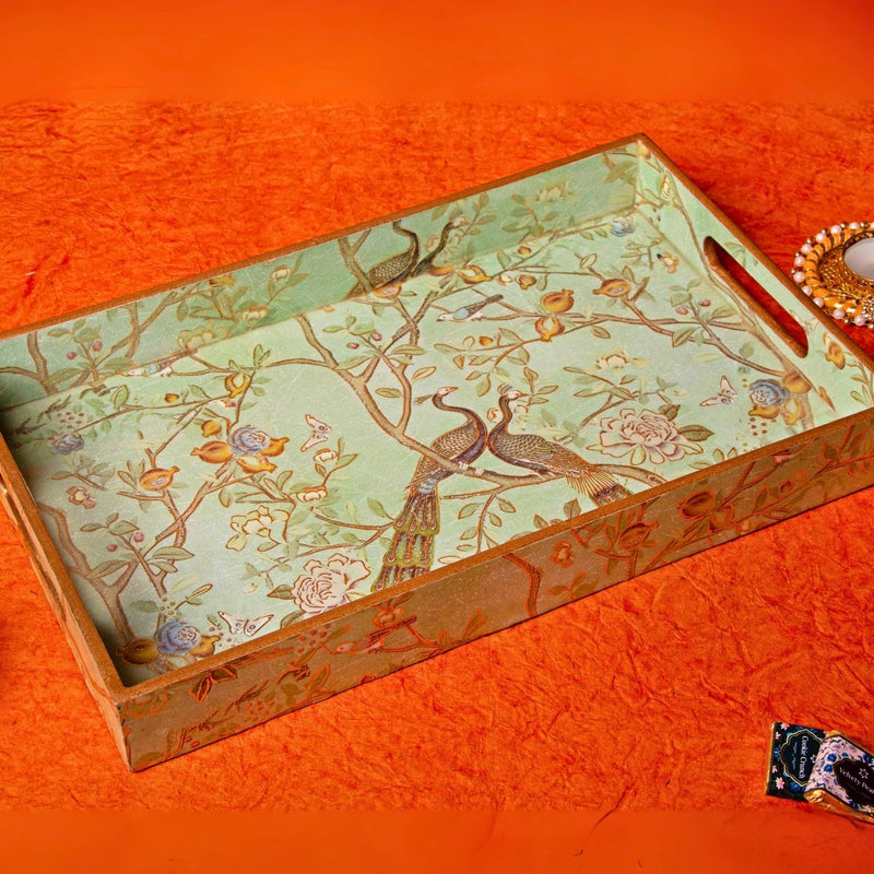 Decorative tray with bird and floral design on an orange fabric background