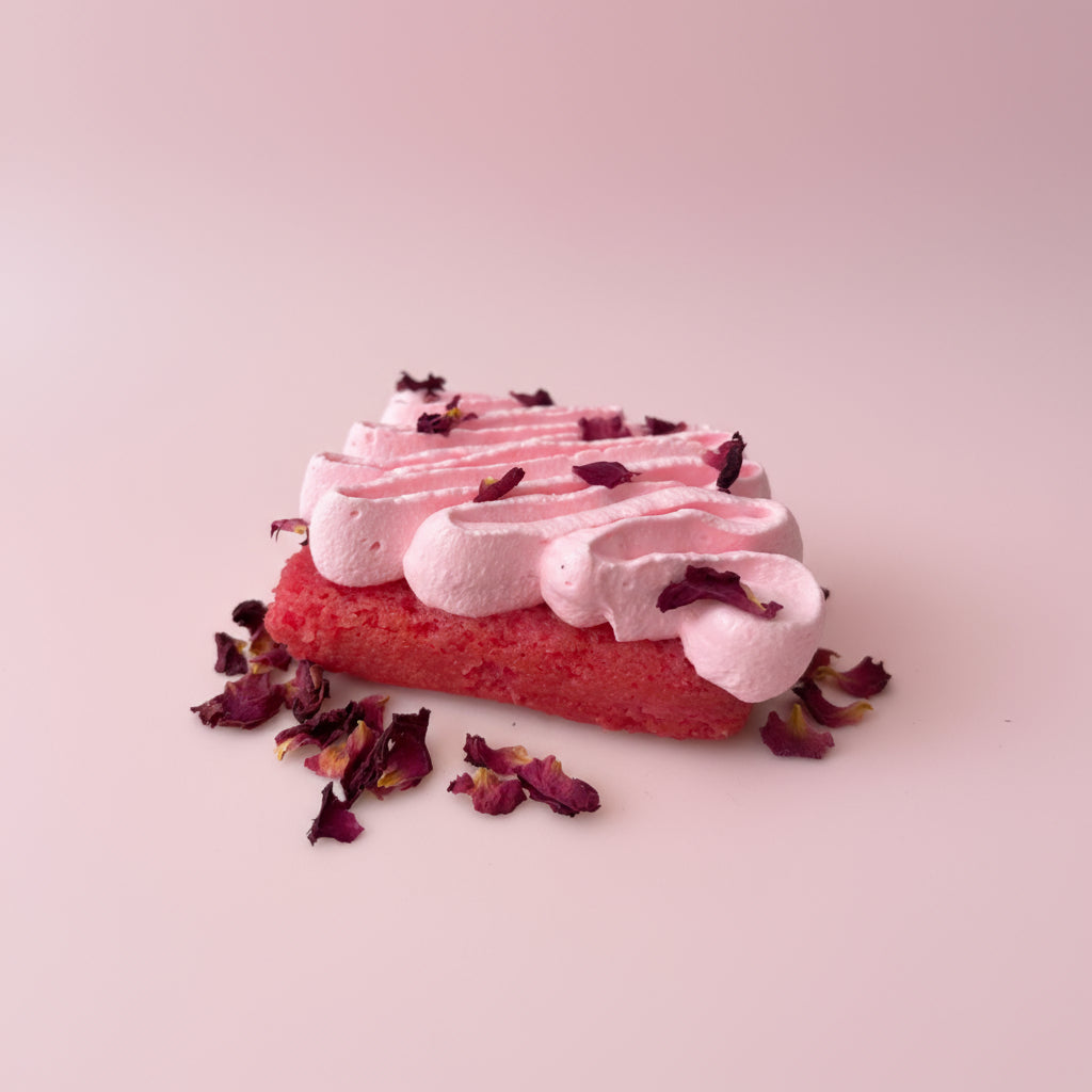 Pink dessert with whipped cream and dried flowers on a light pink background