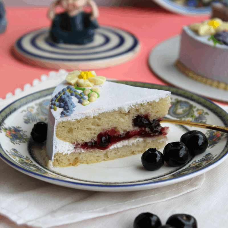 shot of a slice of blueberry cake. best blueberry cake. Bangalore cakes. Bangalore bakeries. bakery cake. vanilla blueberry cake. yummy cakes. delicious cakes. dream a dozen. Aubree. theobroma. crave by Leena. Bangalore. Bengaluru. birthday cakes. pretty cakes. beautiful cakes. aesthetic cake