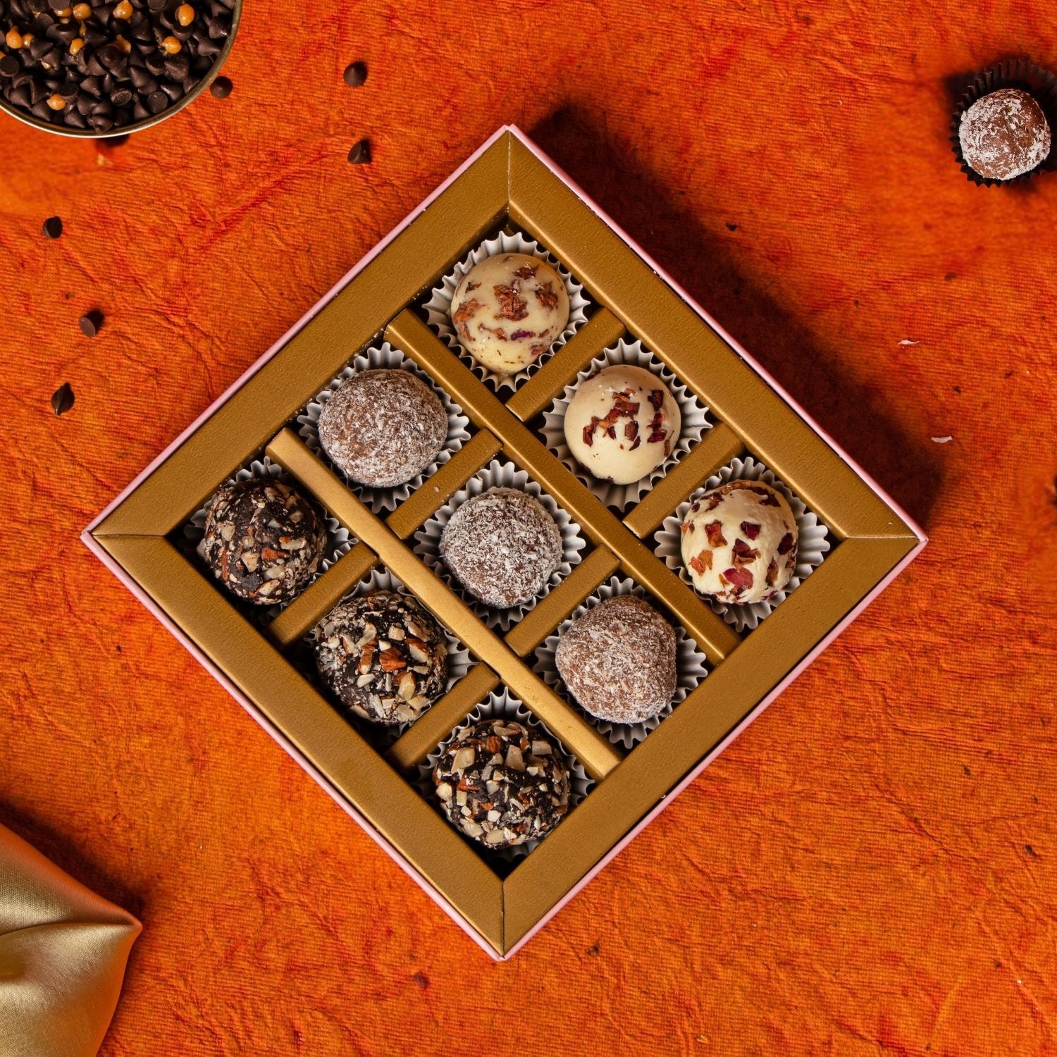 Box of assorted chocolates on an orange surface