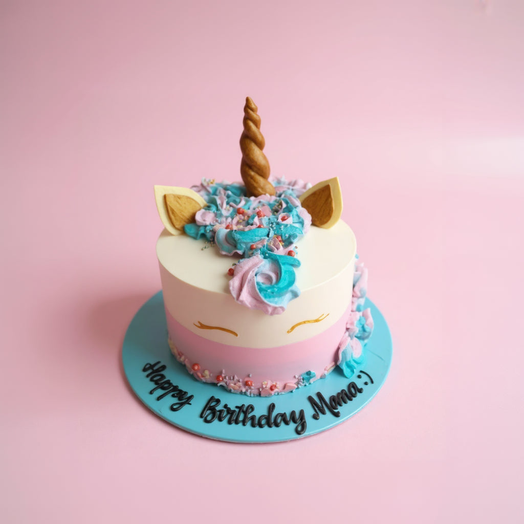 Unicorn-themed birthday cake with colorful decorations on a pink background