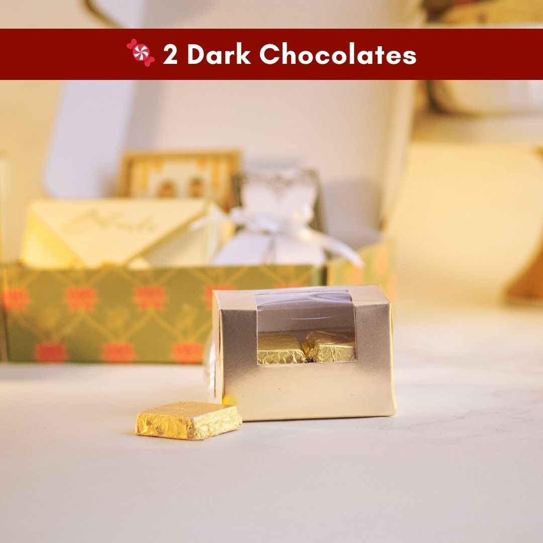 a close up front shot of a simple transparent box with gold borders containing delicious chocolates wrapped in gold foil