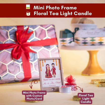 a close up front shot of a customisable mini photo frame with a floral tea light candle in front of it adding to the aesthetic wholesomeness of the hamper